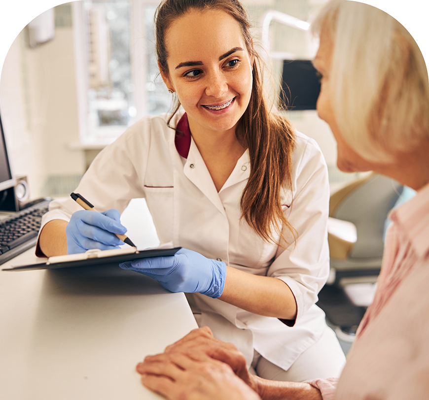 Dental team member listening to a patient and taking notes