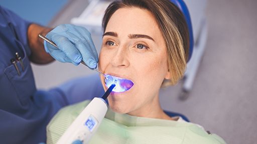 Woman getting cosmetic bonding treatment on a lower tooth
