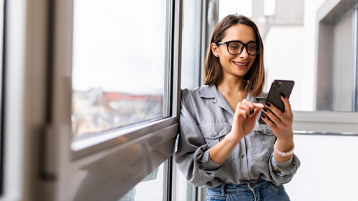 Woman smiling while looking at her phone