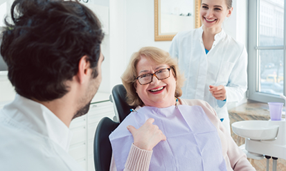 Senior woman smiling at her dentist during a checkup