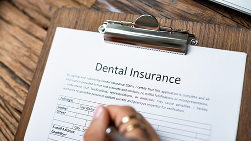 Person filling out a dental insurance form