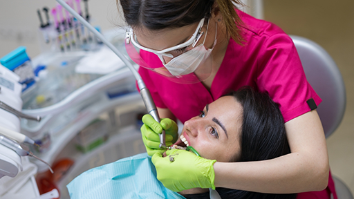 Dental patient having fluoride applied to her teeth