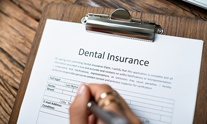 Person filling out dental insurance paperwork