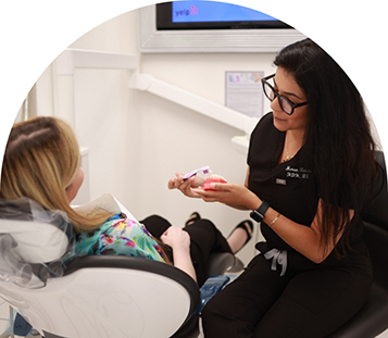 Dental team member showing a patient how to clean a denture