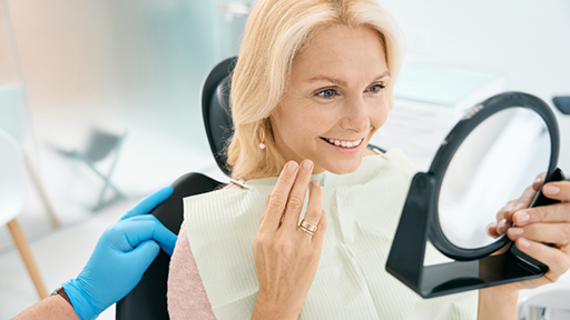 Dental patient admiring her smile in a mirror