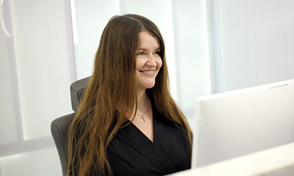 Smiling dental team member at her computer