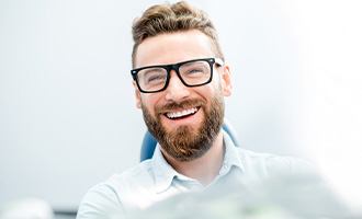 man smiling while sitting in treatment chair