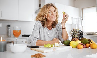 A middle-aged woman eating crisp fruits