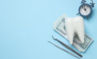 A clock, decorative tooth and money on a blue background